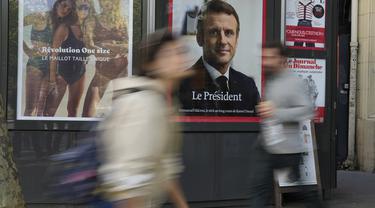 Sebuah potret halaman depan Presiden Emmanuel Macron ditampilkan di sebuah stand berita, di Paris, Prancis, Senin (25/4/2022).&nbsp; Emmanuel Macron akhirnya berhasil memperpanjang masa jabatannya sebagai Presiden Prancis hingga lima tahun ke depan pada hari Minggu, setelah mengalahkan kandidat dari partai sayap kanan Marine Le Pen. (AP Photo/Francois Mori)