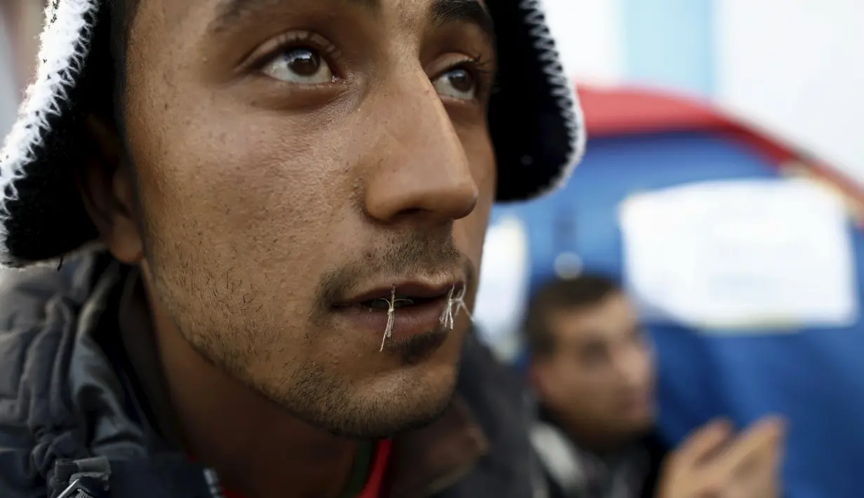 Aksi Yosri Adjili (25), seorang pengangguran saat melakukan mogok makan dan menjahit mulutnya ketika berunjuk rasa menuntut diberikan pekerjaan, di halaman kantor pemerintah setempat di Kasserine, Tunisia, Rabu (27/1). (REUTERS/Zohra Bensemra) 