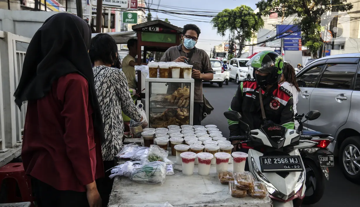 Pedagang menu berbuka puasa atau takjil melayani pembeli jelang waktu berbuka puasa di kawasan Radio Dalam, Jakarta Selatan, Senin (4/4/2022). Pedagang musiman yang menjual aneka takjil memanfaatkan momen bulan suci Ramadhan 1443 H. (Liputan6.com/Johan Tallo)