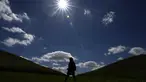 Seorang wanita berjalan di antara gundukan tanah di Northala Fields Country Park di London, Senin, 21 Agustus 2023. (AP Photo/Kirsty Wigglesworth)