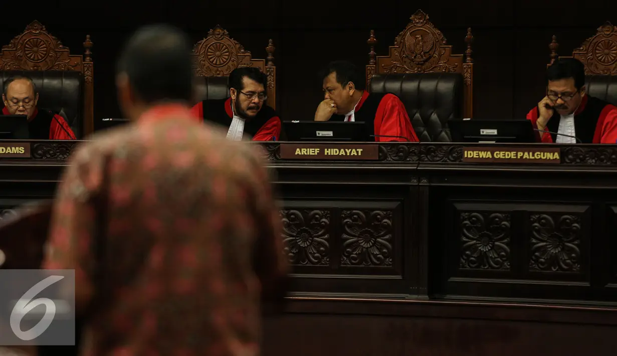 Ketua Mahkamah Konstitusi, Arief Hidayat (kedua kanan) berbincang dengan Wakil Ketua MK, Anwar Usman saat sidang Uji Materi UU KPK  di Mahkamah Kontitusi, Jakarta, Selasa (23/6/2015). (Liputan6.com/Faizal Fanani)
