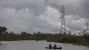 Warga menyeberangi banjir dengan sampan yang disebabkan oleh Boom Sungai Wawa setelah melintas Badai Iota di Bilwi, Puerto Cabezas, Nikaragua (18/11/2020). Badai Iota telah menewaskan sedikitnya sembilan orang saat menghancurkan rumah, menumbangkan pohon dan menggenangi air. (AFP/Inti Ocon)