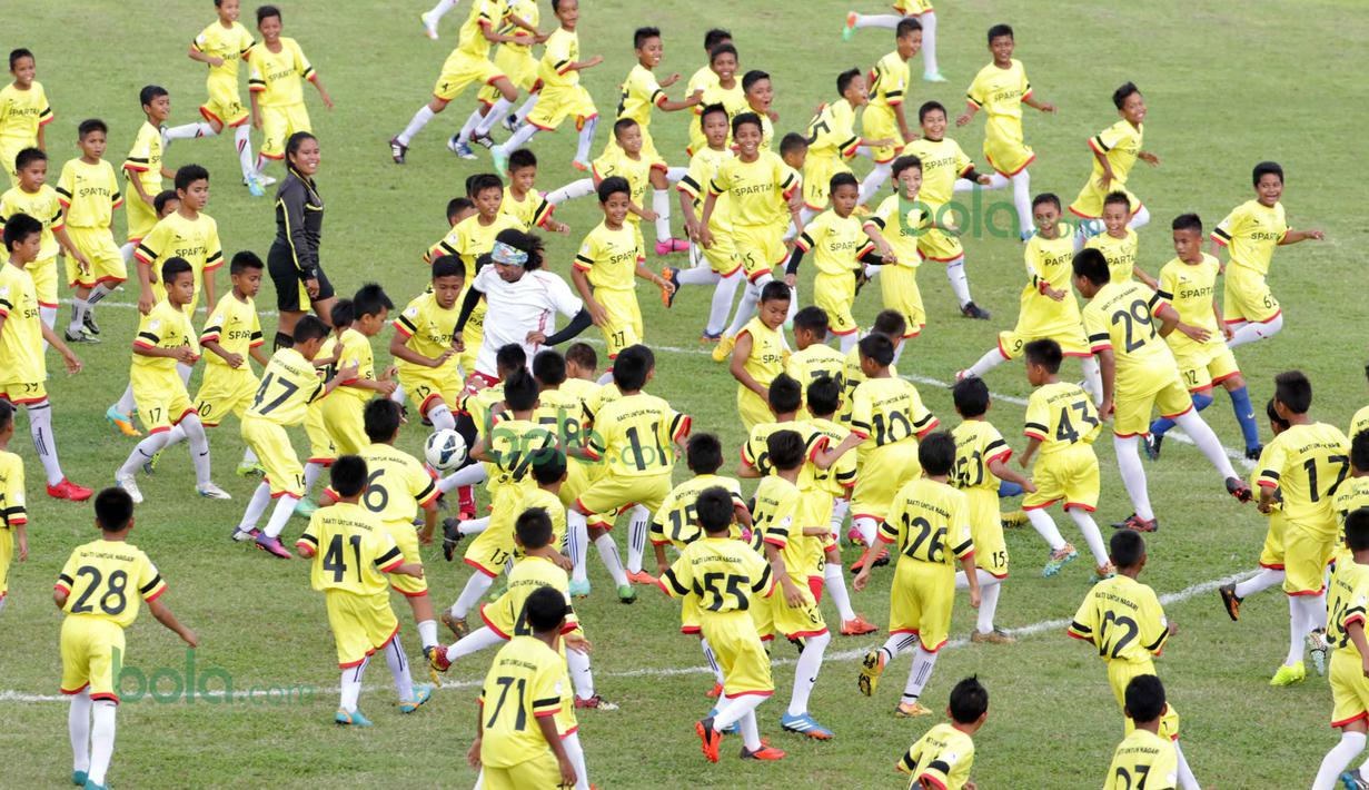 Ratusan Anak-anak SSB kota Padang berlari menghadang Legenda Timnas Indonesia Rocky Putiray  pada ajang Irman gusman Cup 2016 diStadion Agus Salim, Padang, Minggu (13/3/2016). (Bola.com/Nicklas Hanoatubun)