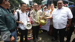 Menteri Tenaga Kerja dan Transmigrasi Hanif Dhakiri menyerahkan bantuan tabung gas secara simbolis saat melepas keberangkatan rombongan Pendukung Jokowi Peduli Garut di Tugu Proklamasi, Jakarta, Rabu (28/9). (Liputan6.com/Immanuel Antonius) 