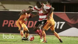 Pemain Madura United, Greg Nwokolo, dihadang dua pemain Pusamania Borneo FC pada babak delapan besar Piala Presiden 2017 di Stadion Manahan, Solo. Jumat (25/2/2017). (Bola.com/Nicklas Hanoatubun)