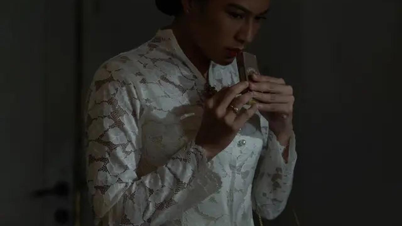Dian Sastro tampil memesona dengan kebaya putih yang memikat, lengkap dengan detail leher yang unik.