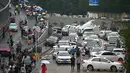 Orang-orang melihat mobil-mobil yang terendam banjir setelah hujan lebat di Zhengzhou, provinsi Henan, China, Kamis (22/7/2021). Hujan yang membanjiri jalan-jalan membuat pengendara terpaksa menempuh banjir setinggi pinggang yang menenggelamkan atau menghanyutkan banyak mobil. (Noel Celis/AFP)