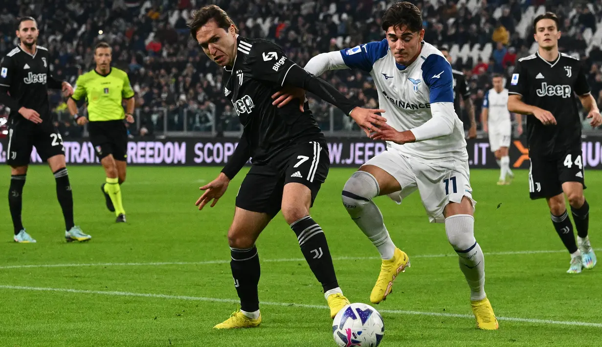 Penyerang Juventus Federico Chiesa (Kiri) dan penyerang Lazio Matteo Cancellieri saling berebut bola  pada pekan ke-15 Serie A 2022/2023 di Allianz Stadium, Senin (14/11/2022) dini hari WIB. Juventus kini masih terpaut 10 angka dengan Napoli yang berada di pemuncak klasemen Liga Italia. (Vincenzo PINTO / AFP)