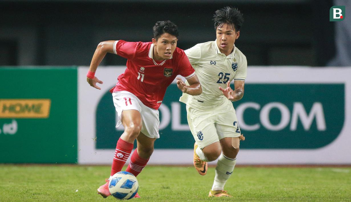 <p>Pemain Timnas Indonesia U-19,&nbsp;Ferdiansyah Cecep Surya&nbsp;menggiring bola&nbsp;dibayangi pemain Timnas Thailand U-19, Phon-Ek Maneekorn dalam pertandingan babak penyisihan Grup A Piala AFF U-19 yang berlangsung di Stadion Patriot Candrabhaga, Bekasi, Rabu (6/7/2022). (Bola.com/Bagaskara Lazuardi)</p>