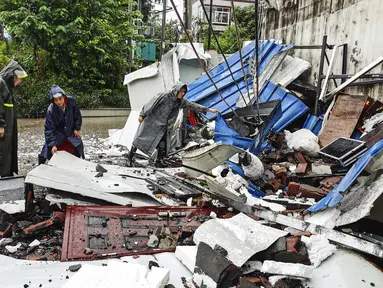 Para pekerja memeriksa puing-puing setelah gempa bumi di daerah Luxian di provinsi Sichuan China barat daya, Kamis (16/9/2021). Gempa bumi meruntuhkan rumah, menewaskan tiga orang dan melukai belasan lainnya. (Chinatopix Via AP)