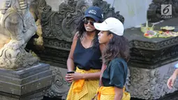 Dua putri Presiden ke-44 AS Barack Obama, Malia dan Sasha, mengunjungi Pura Tirta Empul, Tampaksiring, Gianyar, Bali, Selasa (27/6). Di pura bersejarah tersebut kedua putri Obama kompak mengenakan sarung warna kuning.  (Liputan6.com/Immanuel Antonius)