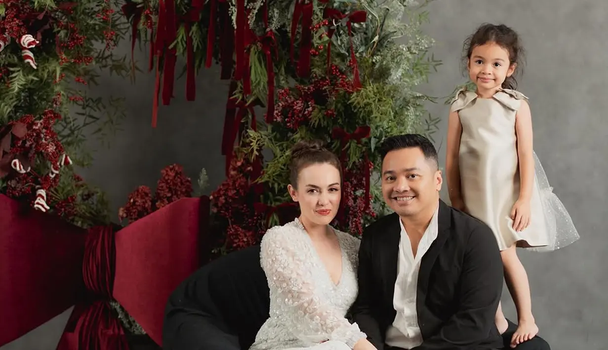 Rianti Cartwright tampil elegen dengan dress putih simpel dan rambut disanggul. Sementara sang suami gagah dengan setelah jas. Dalam momen ini buah hatinya tak kalah mencuri perhatian karena mengenakan dress sleveless selutut. Usianya telah menginjak 4 tahun, senyuman manis yang dipancarkan membuat tak sedikit netizen gemas dengan anak semata wayang Rianti ini. (Liputan6.com/IG/@riantic)