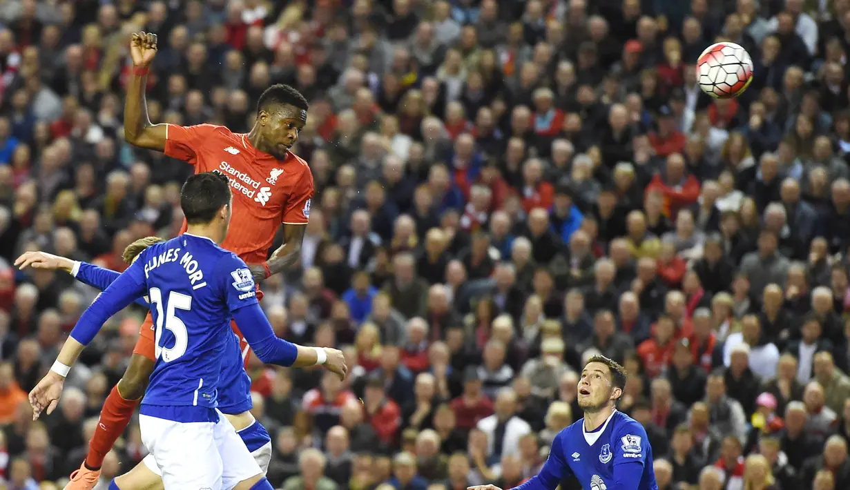 Pemain Liverpool, Divock Origi (kanan), menyundul bola melewati hadangan pemain Everton pada lanjutan Liga Inggris di Stadion Anfield, Liverpool, Kamis (21/4/2016) dini hari WIB. (AFP/Paul Ellis)