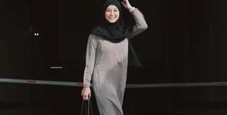 Awkarin mengunggah beberapa potret dirinya yang akhirnya pergi menjalankan ibadah Umroh bersama keluarga dan sahabat. Di sini, Awkarin tampil manis mengenakan gamis abu-abu dan hijab hitam serba polos. [Foto: Instagram/narinkovilda]