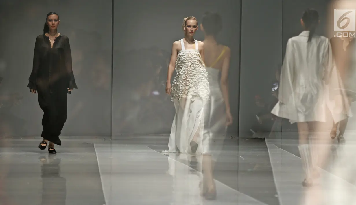 Sejumlah model berjalan diatas catwalk membawakan rancangan Jeffry Tan yang berkolaborasi dengan shampo Serasoft di JFW 2018 di Senayan City, Jakarta, Selasa (25/10). Rancangan kali ini bertema Prime Collection. (Liputan6.com/Herman Zakharia)