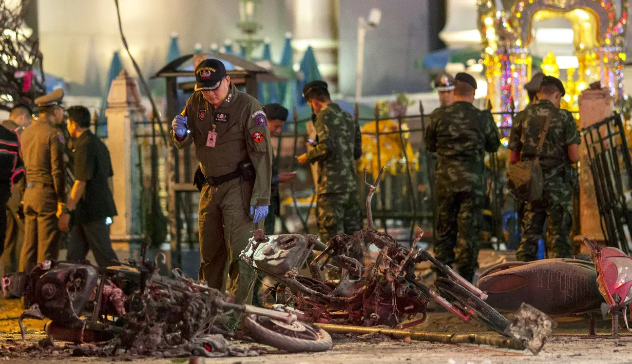 Sejumlah petugas melakukan penyelidikan di lokasi meledaknya bom motor di luar Kuil Erawan di pusat kota Bangkok, Thailand, Senin (17/8/2015). Bom motor tersebut diketahui telah menewaskan sekitar 27 warga. (REUTERS/Athit Perawongmetha)