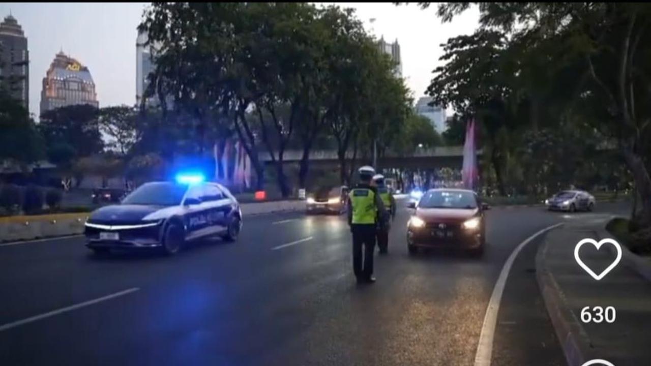 Di lokasi nampak sejumlah personel polisi berjaga-jaga. Sebuah mobil berwarna merah yang hendak masuk ke jalur iring-iringan pun ditepikan oleh petugas.<br>