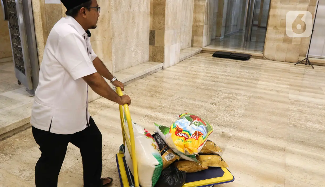 Petugas memindahkan zakat fitrah warga di Masjid Istiqlal. (Liputan6.com/Herman Zakharia)