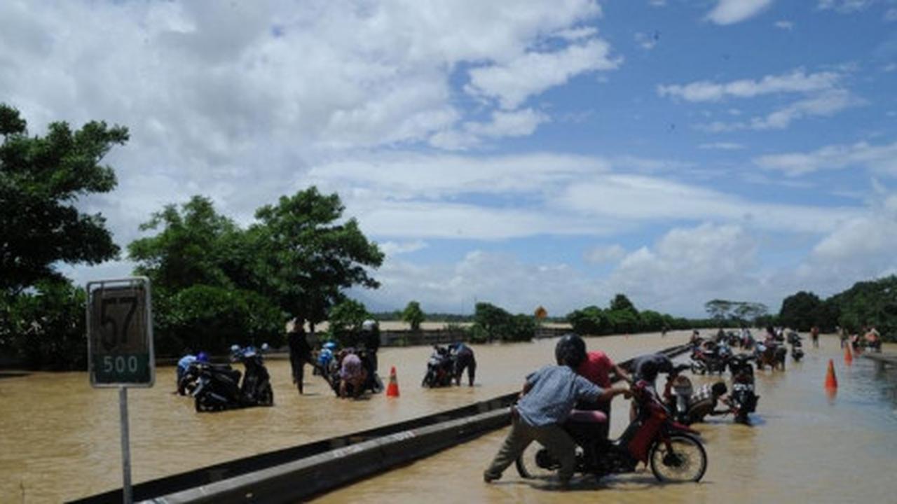Cuci sepeda motor dengan air banjir