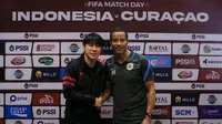 Pelatih kepala Timnas Indonesia, Shin Tae-yong (kiri) dan Pelatih kepala Curacao, Remko Bicentini berpose di depan wartawan usai memberikan keterangan saat konferensi pers menjelang laga FIFA Match Day antara Timnas Indonesia melawan Timnas Curacao yang berlangsung di Hotel Harris Citylink, Bandung, Jumat (23/06/2022). (Bola.com/Bagaskara Lazuardi)