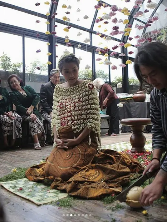 Dominique memakai kemben berwarna merah dengan rangkaian bunga melati di bagian dada dan bandana di kepalanya. Serangkaian prosesi adat dijalani Dominiqueseperti siraman dan sungkeman kepada kedua orang tua. (Instagram/dominiquediyose)