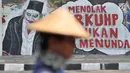 Mural bertulis 'Menolak RKUHP Bukan Menunda' terpampang pada dinding di Jalan Pemuda, Rawamangun, Jakarta, Selasa (1/10/2019). Mural tersebut respons dari seniman Jakarta terhadap RUU KUHP yang dinilai mencederai tatanan demokrasi. (merdeka.com/Iqbal Nugroho)