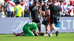 Kiper Kanada, Maxime Crepeau memberikan pertolongan kepada asisten wasit Humberto Panjoj saat mengalami pingsan pada laga Grup A Copa America 2024 antara Peru melawan Kanada di Children's Mercy Park, Kansas City, Kansas, Selasa (25/06/2024) waktu setempat. (AFP/Getty Images/Jamie Squire)
