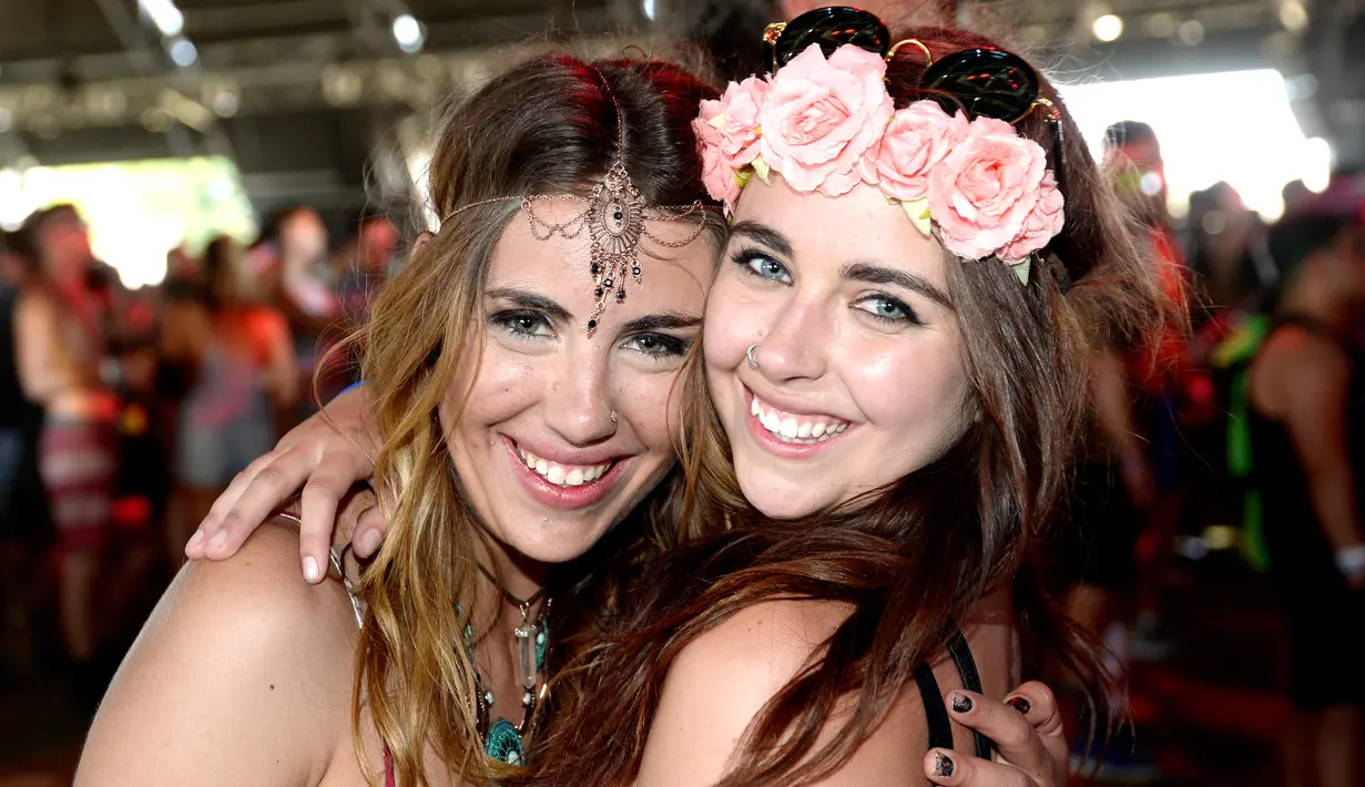  Senyum manis dua wanita saat menghadiri hari pertama Coachella Valley Music and Arts Festival 2016 di Empire Polo Club, Indio, California (15/4). Festival Coachella ini sudah ada sejak 1999. (AFP/Michael Tullberg)