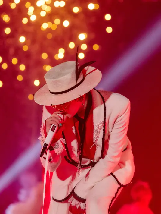 Melengkapi tampilannya dengan topi fedora putih. Serta kacamata lensa kuning besar. GD juga mengenakan syal yang dijadikan dasi warna hitam. [Dok. CHANEL]