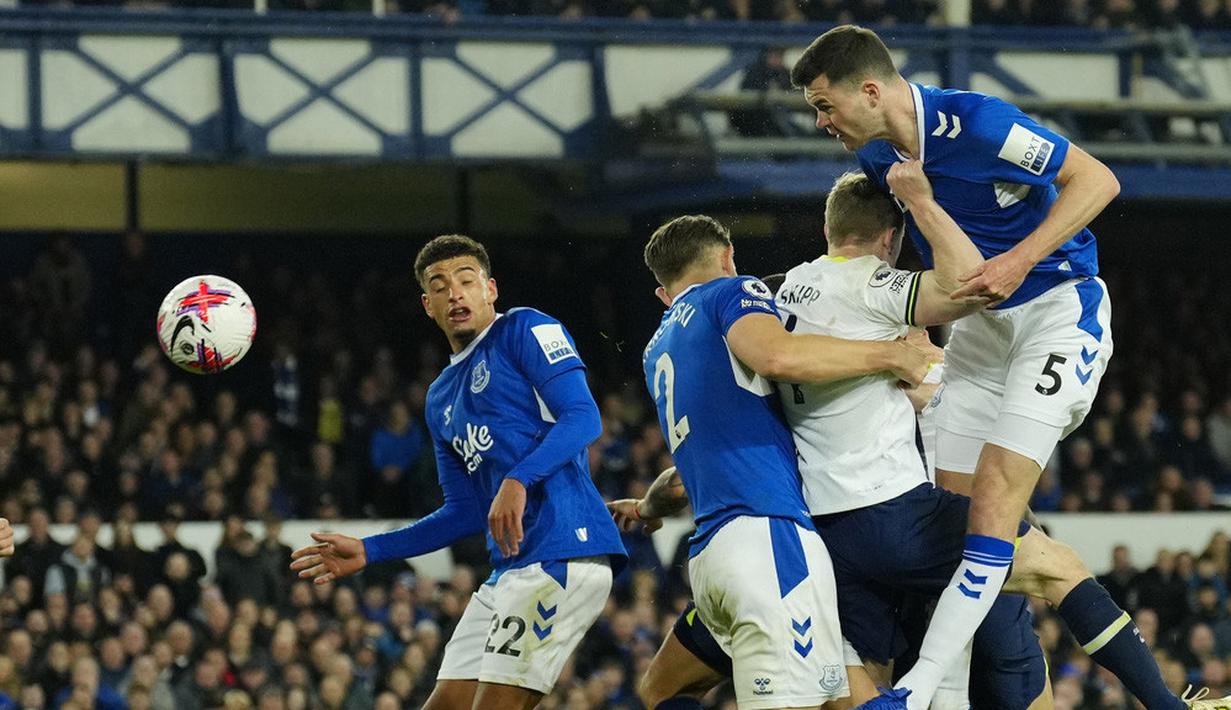 Pemain Everton, Michael Keane, menyundul bola saat melawan Tottenham Hotspur pada laga Liga Inggris di Stadion Goodison Park, Selasa (4/4/2023). Dengan tambahan satu poin, Spurs berhasil mengkudeta posisi Manchester United di peringkat empat klasemen sementara. (AP Photo/Jon Super)