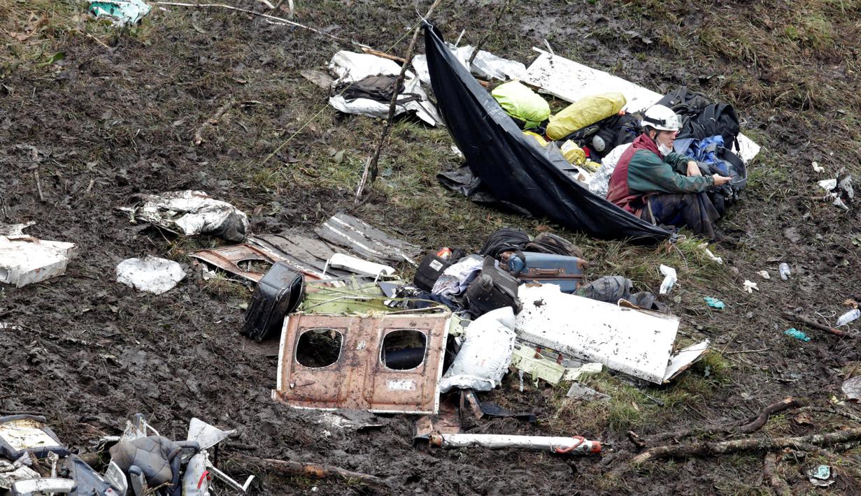 Seorang tim regu penyelamat duduk diantara puing-puing pesawat  LaMia Airlines yang terjatuh di areal hutan Kolombia, (29/11/2016).  (Reuters/Jaime Saldarriaga)