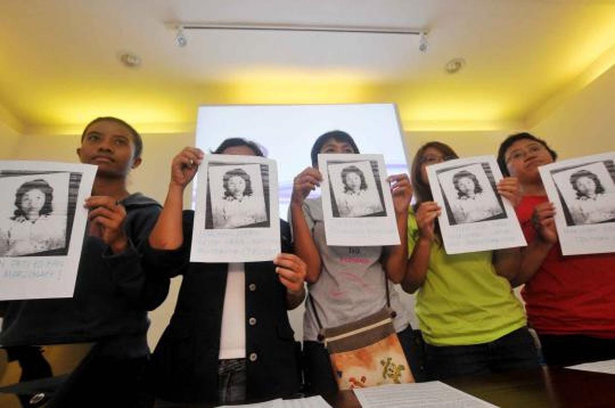 Seorang aktivis menuliskan pesan di foto Marsinah saat konferensi pers 
