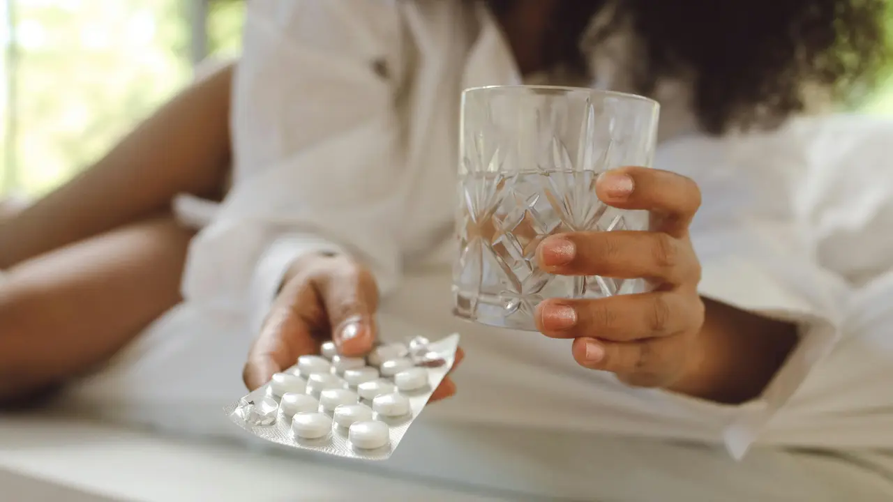 Wanita sedang minum obat