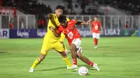 Pemain Malut United, Ilham Udin Armaiyn, berebut bola dengan pemain Semen Padang, Agus Nova, pada laga leg pertama semifinal Pegadaian Liga 2 2023/2024 di Stadion Madya, Jakarta, Minggu (25/02/2024). (Bola.com/M Iqbal Ichsan)