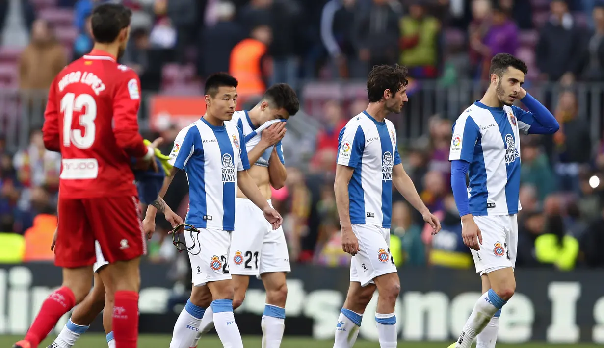 Pemain Espanyol tampak lesu usai ditaklukkan Barcelona pada laga La Liga di Stadion Camp Nou, Sabtu (30/3). Barcelona menang 2-0 atas Espanyol. (AP/Manu Fernandez)