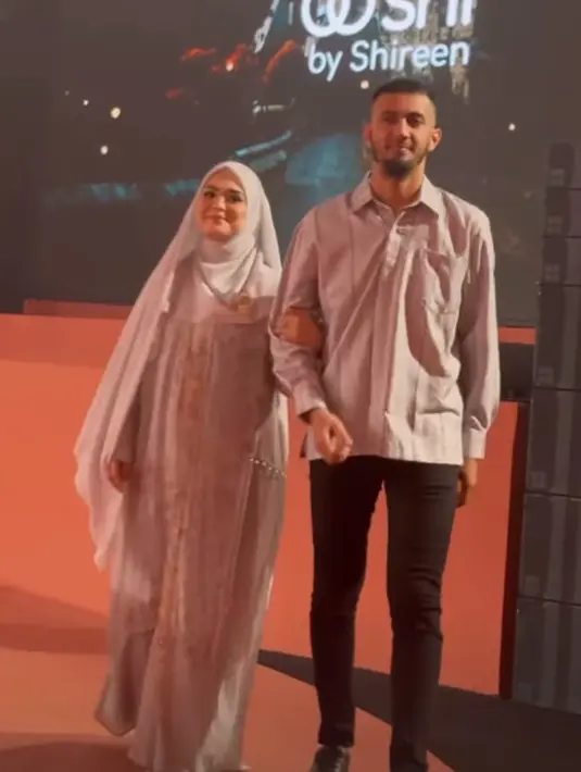 Vebby kenakanleated dress dan outer chiffon. Sang suami kenakan kemeja satin panjang bermotif serupa [@vebbypalwinta]