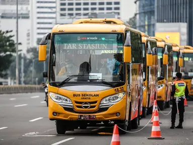 Bus sekolah terparkir di Kawasan Stasiun Sudirman, Jakarta, Jumat (19/6/2020). Dishub DKI Jakarta telah mengerahkan 50 armada bus sekolah untuk membantu mengurai lonjakan penumpang KRL yang ditempatkan di lima stasiun Tanah Abang, Manggarai, Juanda, Sudirman dan Tebet. (Liputan6.com/Faizal Fanani)