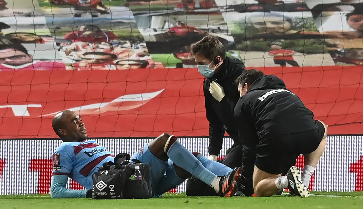 Bek West Ham United, Angelo Ogbonna mendapat perawatan medis usai mengalami cedera dalam laga babak kelima Piala FA 2020/21 melawan Manchester United di Old Trafford Stadium, Selasa (9/2/2021). West Ham kalah 0-1 (0-0) dari Manchester United melalui extra time. (AFP/Michael Regan/Pool)