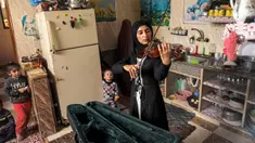 Musisi Palestina Jawaher al-Aqraa memainkan biola sambil berdiri di dapur rumahnya di Deir al-Balah, Jalur Gaza Tengah, 24 Oktober 2023. (Eyad BABA/AFP)