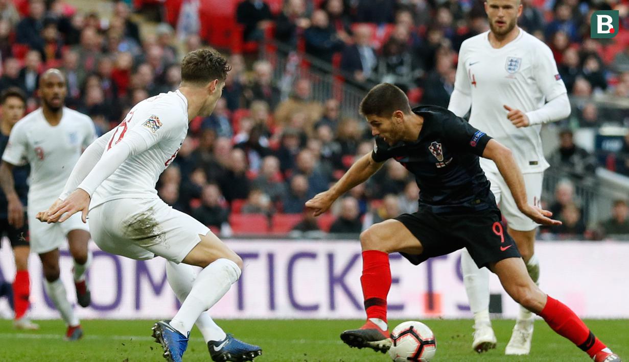 Striker Kroasia, Andrej Kramaric, berusaha melewati bek Inggris, John Stones, pada laga UEFA Nations League di Stadion Wembley, London, Minggu (18/11). Inggris menang 2-1 atas Kroasia. (AFP/Adrian Dennis)