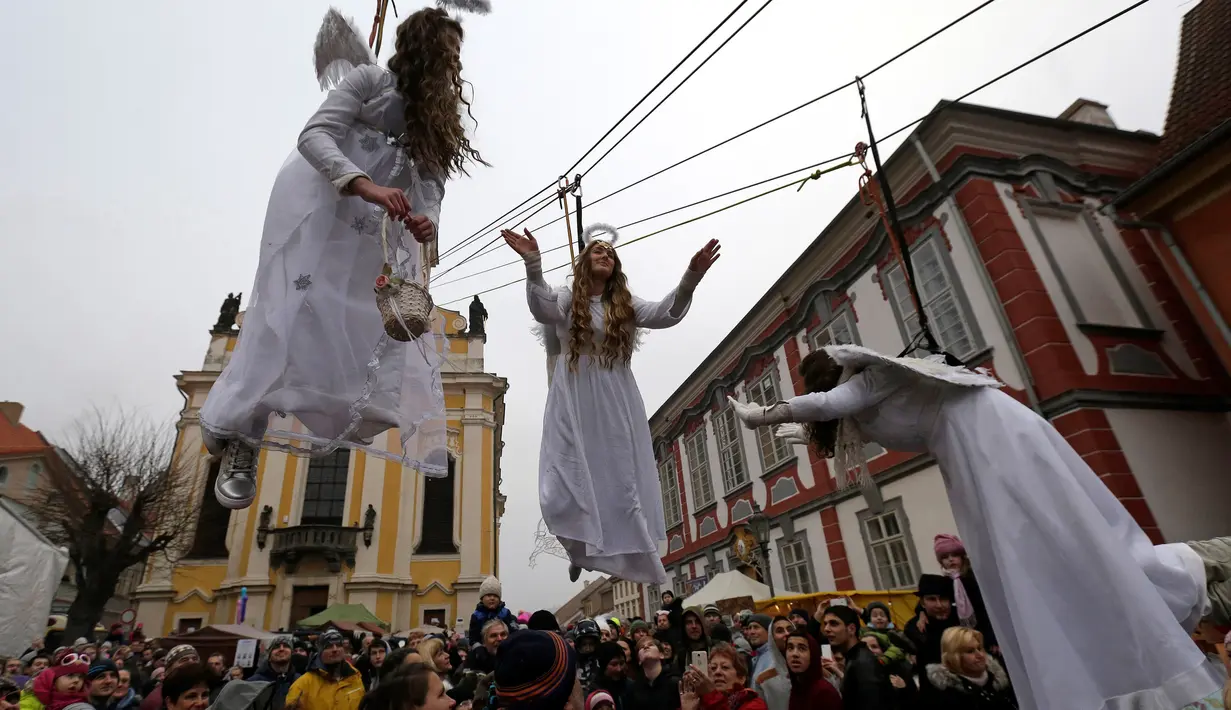 Sejumlah wanita berpakaian seperti malaikat berayunan diatas ratusan penonton saat acara pasar Natal di kota Ustek, Republik Ceko (17/12). Mereka melakukan aksi ini dalam rangka untuk menyambut datangnya natal. (Reuters/David W Cerny)