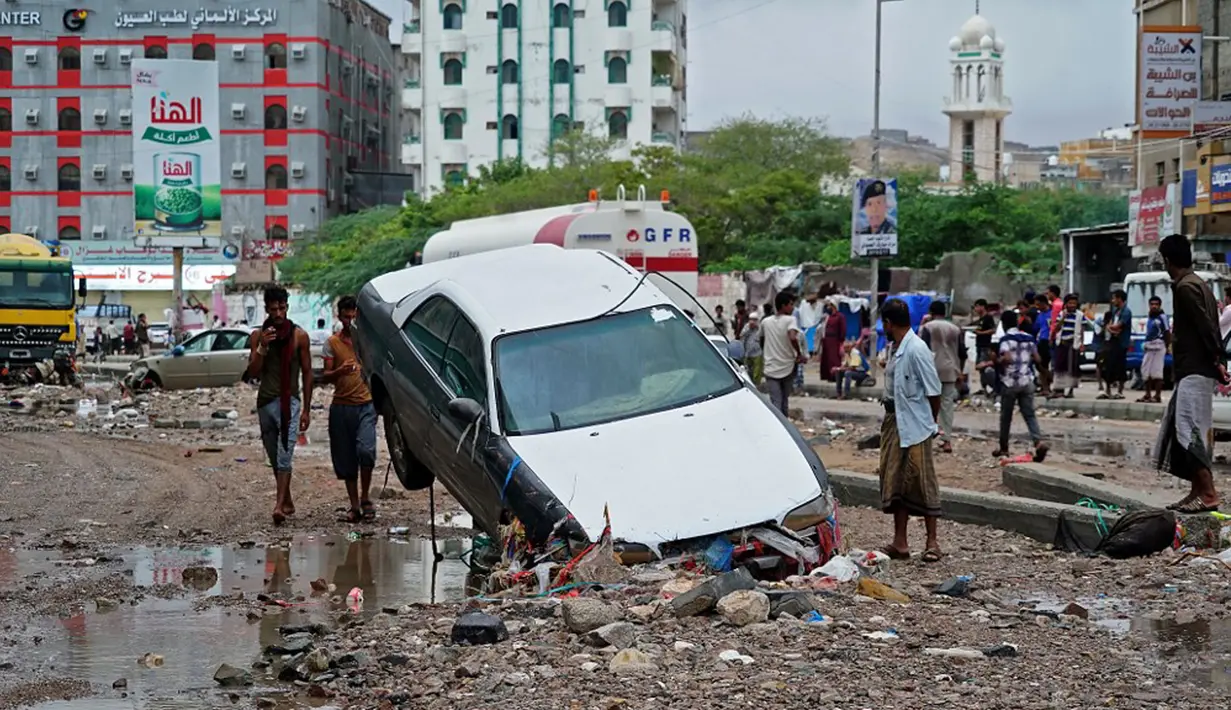 Warga melihat-lihat kerusakan usai banjir yang disebabkan oleh Topan Shaheen di Mukalla, Provinsi Hadramaut, Yaman, Kamis (7/10/2021). Topan Shaheen yang melanda negara tetangga, Oman, mempengaruhi wilayah tersebut. (AFP)