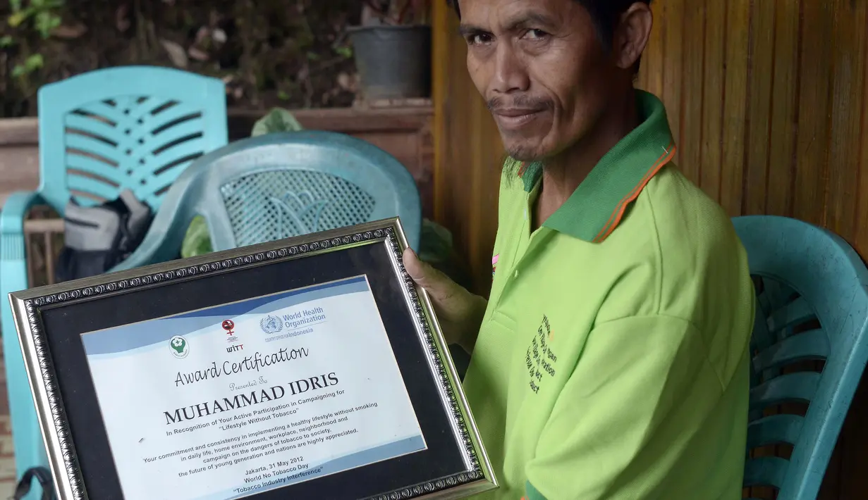 Muhammad Idris, salah satu pelopor antirokok menunjukkan sertifikat atas usahanya menjadikan Desa Bone-Bone, Sulawesi Selatan, bebas asap rokok, 20 Desember 2015. Bagi yang melanggar aturan larangan merokok, diberikan sanksi kerja sosial (Cening Unru/AFP)