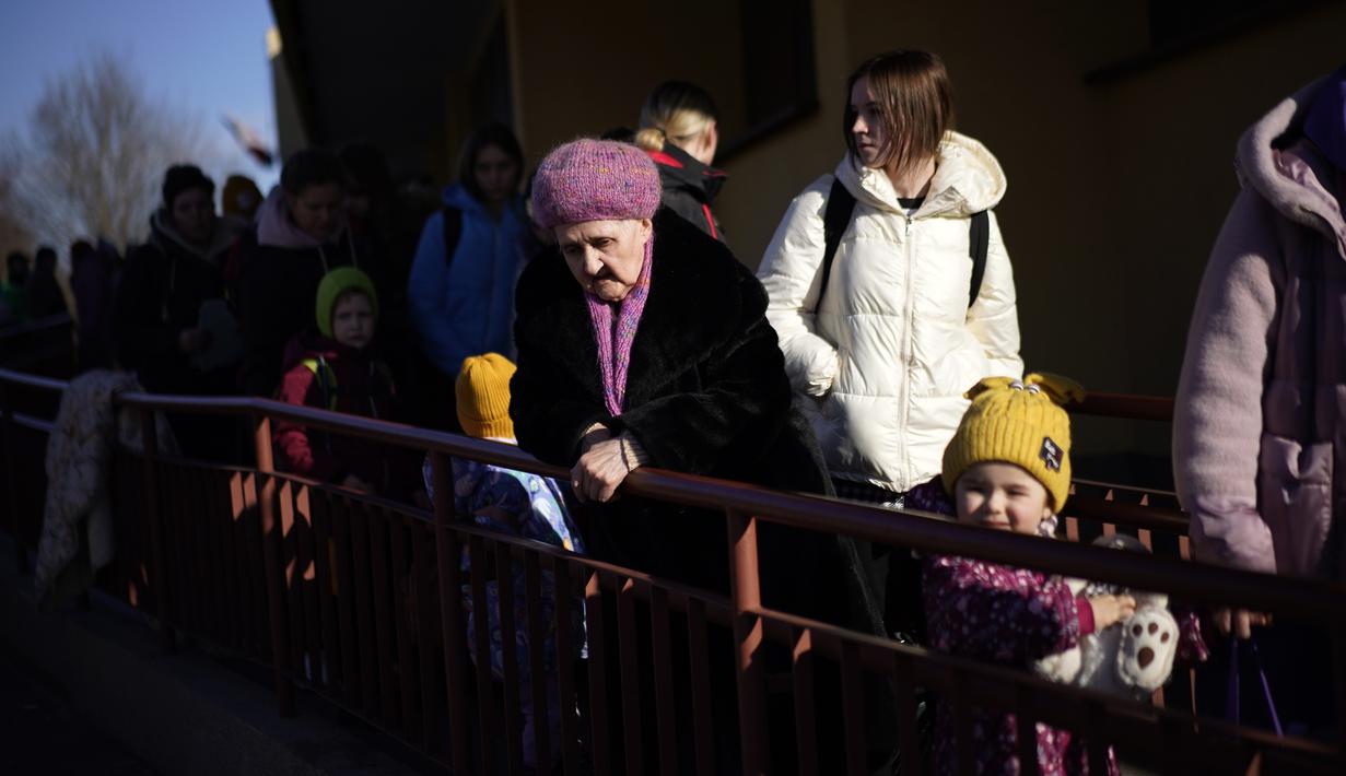Seorang wanita Ukraina berdiri ketika pengungsi lain tiba dari Lviv ke stasiun kereta api Przemysl, Polandia tenggara, pada Jumat (11/3/2022). Invasi Rusia ke Ukraina sudah memasuki hari ke-16 pada hari Jumat ini. (AP Photo/Daniel Cole)