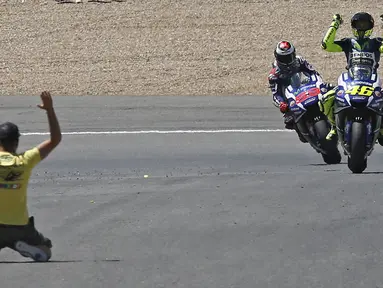 Seorang penonton memasuki lintasan Sirkuit Jerez, Spanyol, setelah Valentino Rossi finis pertama diikuti Jorge Lorenzo dalam balapan MotoGP Jerez, Minggu (24/4/2016). (EPA/Jose Manuel Vidal)