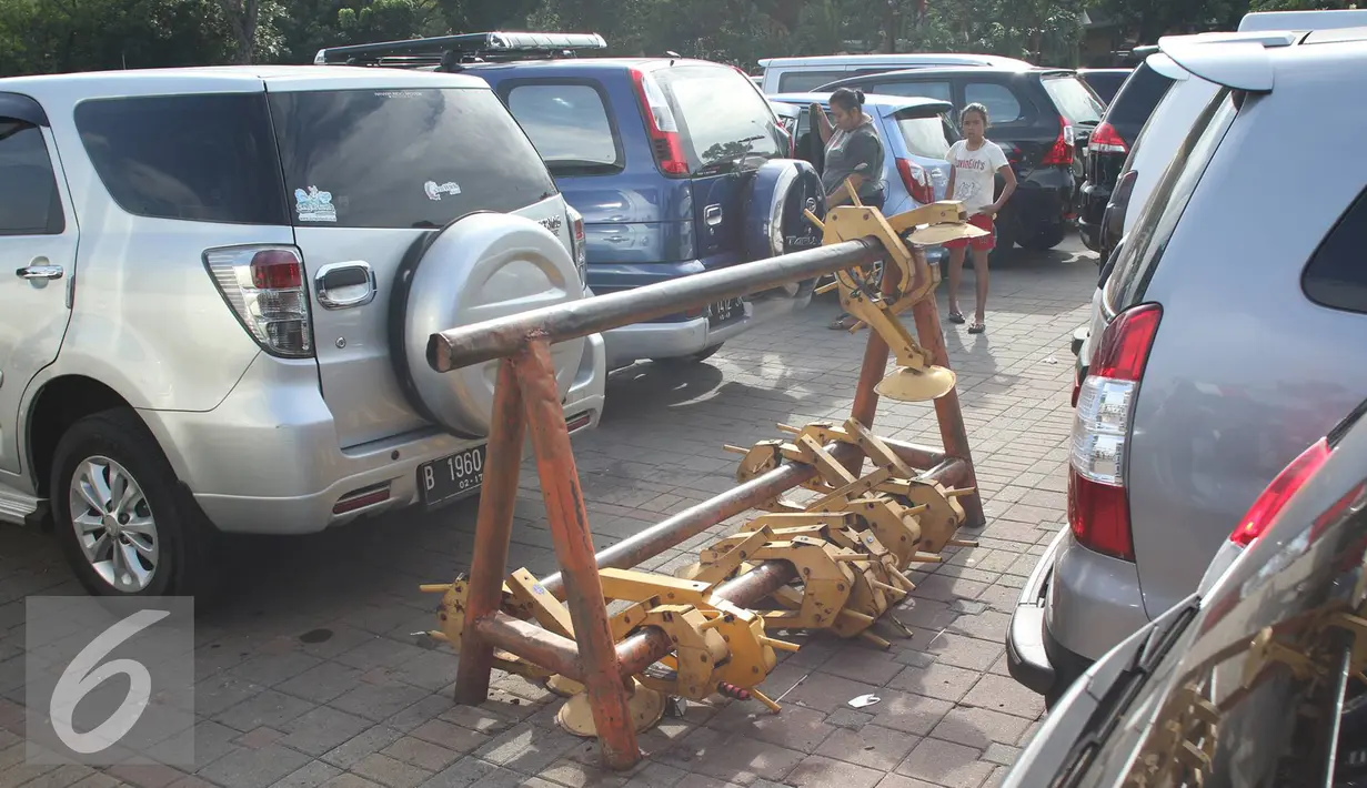 Sejumlah gembok ban mobil yang berada di kawasan Monas, Jakarta, Selasa (3/1). Retribusi derek yang lebih dari Rp 10 miliar tersebut berasal dari 20.472 kendaraan. (Liputan6.com/Immanuel Antonius)