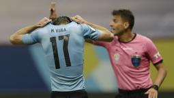 Bek timnas Uruguay, Matias Vina menutupi kepalanya setelah gagal melakukan tendangan penalti dalam laga perempat final Copa America 2021 di Stadion Nacional de Brasilia, Brasil, Minggu (4/7/2021) pagi WIB. Kolombia mengalahkan Uruguay lewat adu penalti dengan skor 4-2. (AP Photo/Silvia Izquierdo)