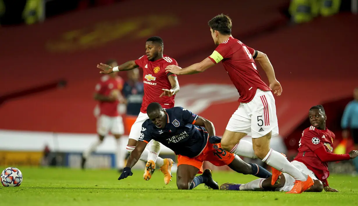Pemain Istanbul Basaksehir Demba Ba terjatuh saat berebut bola dengan pemain Manchester United Harry Maguire pada pertandingan Grup H Liga Champions di Old Trafford, Manchester, Inggris, Selasa (24/11/2020). MU memuncaki Grup H usai menang 4-1 atas Istanbul Basaksehir. (AP Photo/Dave Thompson)
