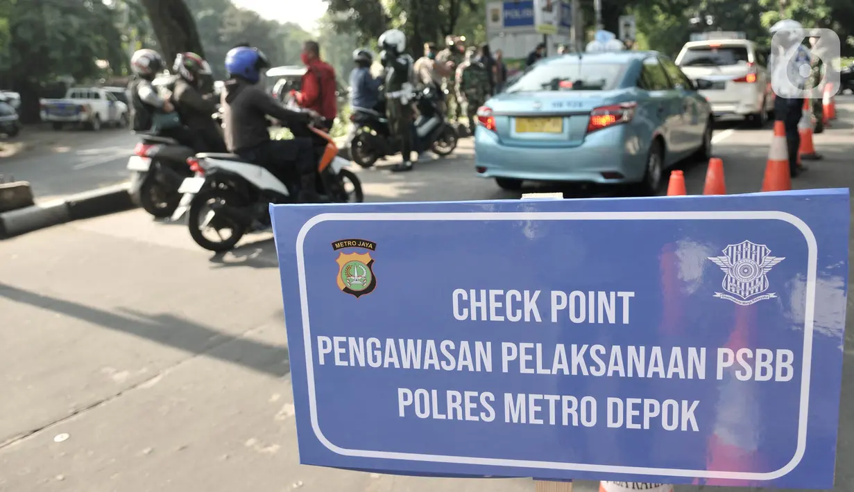 Rambu-rambu peringatan selama hari pertama penerapan Pembatasan Sosial Berskala Besar (PSBB) di Jalan Akses UI, Depok, Jawa Barat, Rabu (15/4/2020). Berdasarkan Peraturan Wali Kota Depok Nomor 22 Tahun 2020, Kota Depok menerapkan PSBB pada 15-28 April 2020. (merdeka.com/Iqbal S Nugroho)