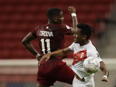 Gelandang timnas Peru, Renato Tapia berebut bola dengan penyerang Venezuela, Sergio Cordova pada laga terakhir penyisihan Grup B  Copa America 2021 di Estadio Nacional Mane Garrincha, Minggu (27/6/2021). Menghadapi Venezuela, Peru menang tipis dengan skor 1-0. (AP Photo/Bruna Prado)